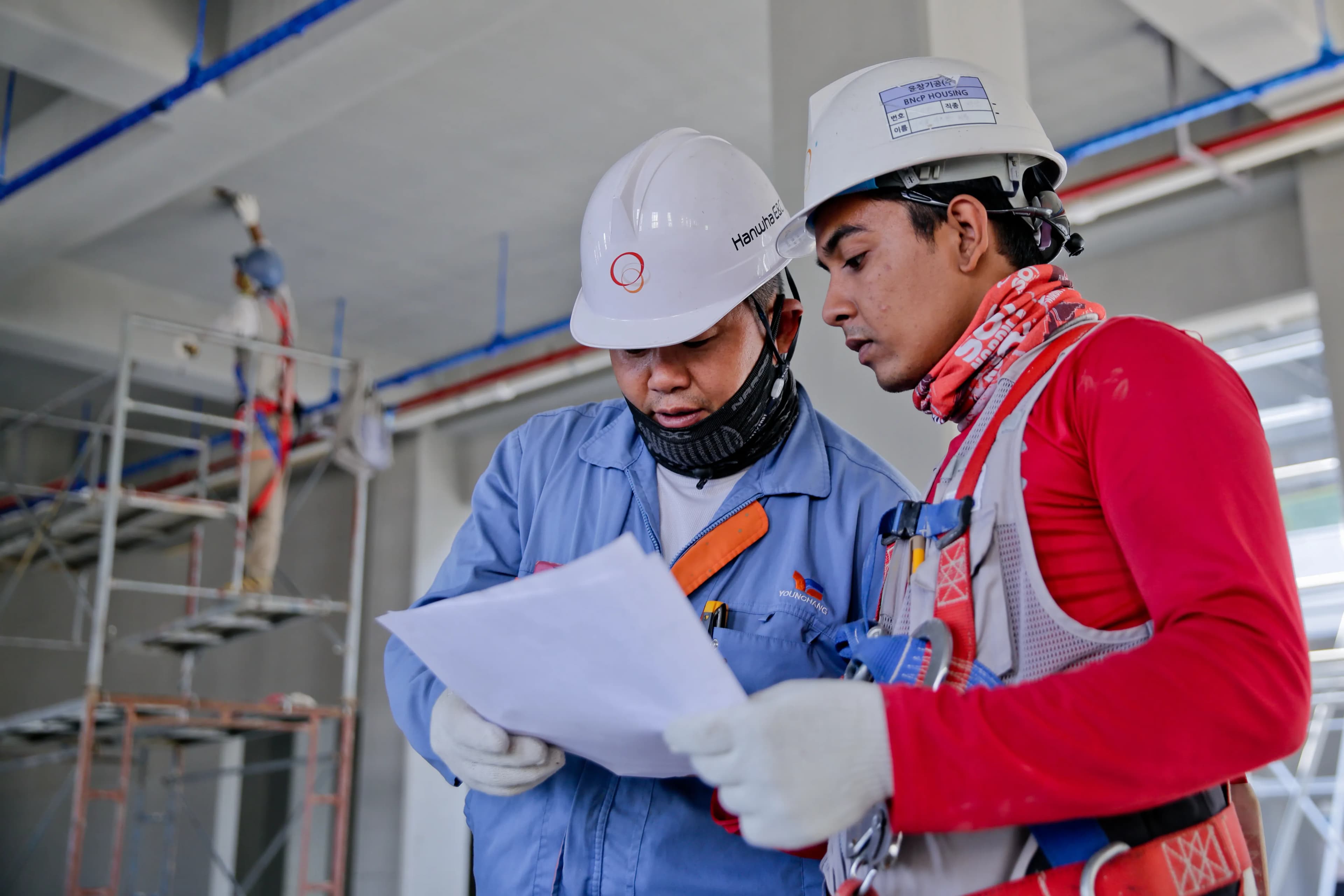 Two construction workers reviewing plans on site